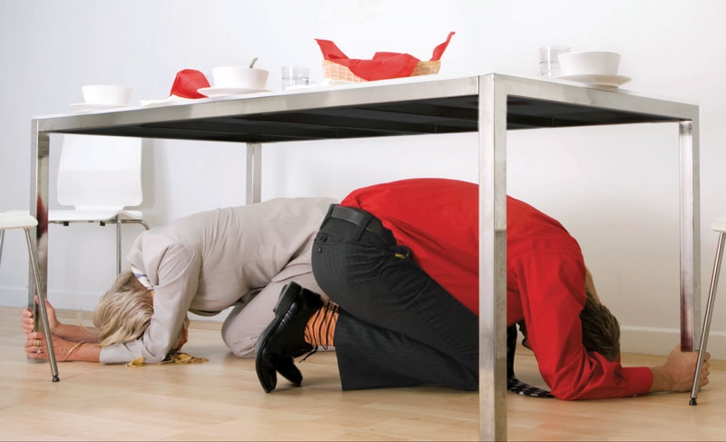 two people under a table holding on