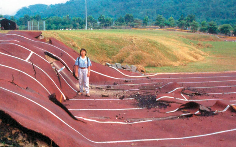 A Taiwan students standing on a school track that was completely destroyed by an earthquake