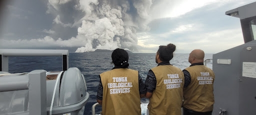 Scientists with the Tonga Geological Survey observe the volcanic eruption from a boat